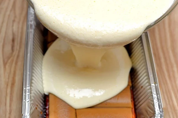 ریختن مخلوط پنیر و خامه روی بیسکوییت